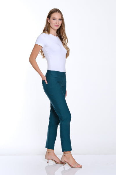 Woman wearing a white top and teal pants on a white background
