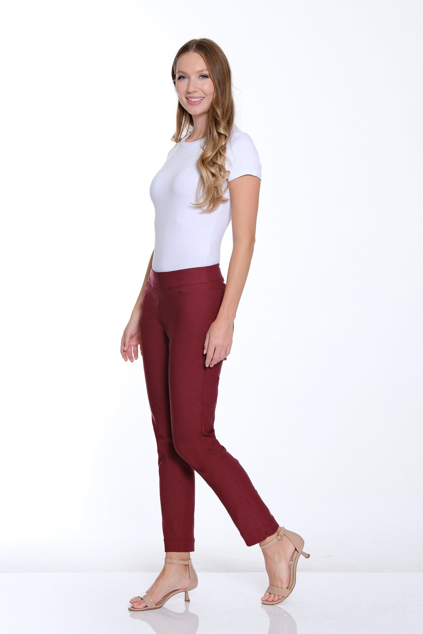 Woman wearing a white top and maroon pants on a white background