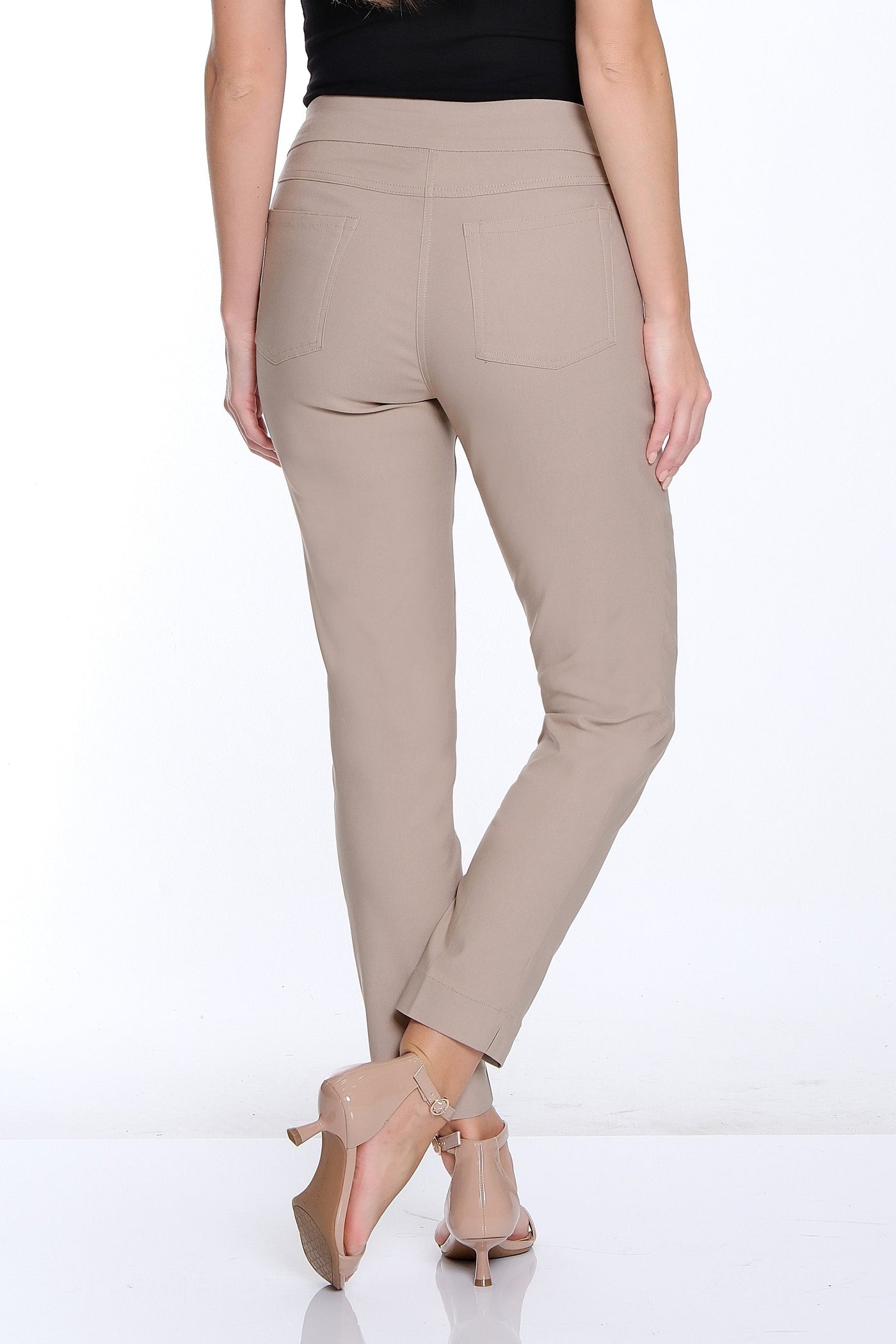 Woman wearing a black top and beige pants on a white background