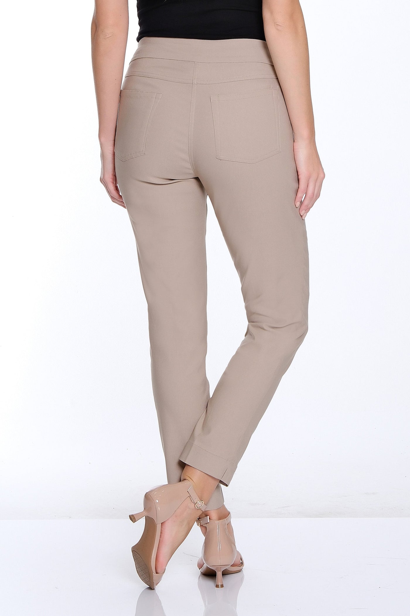Woman wearing a black top and beige pants on a white background