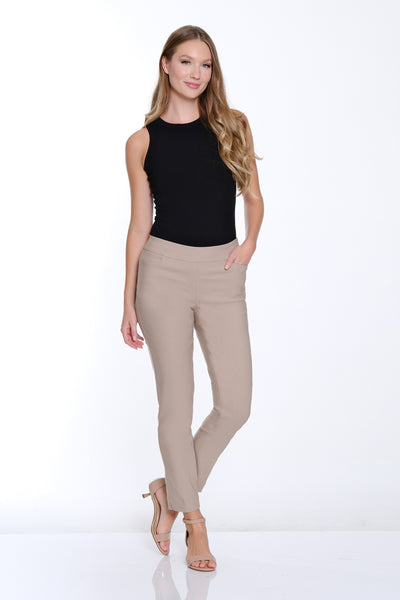 Woman wearing a black sleeveless top and beige pants on a white background