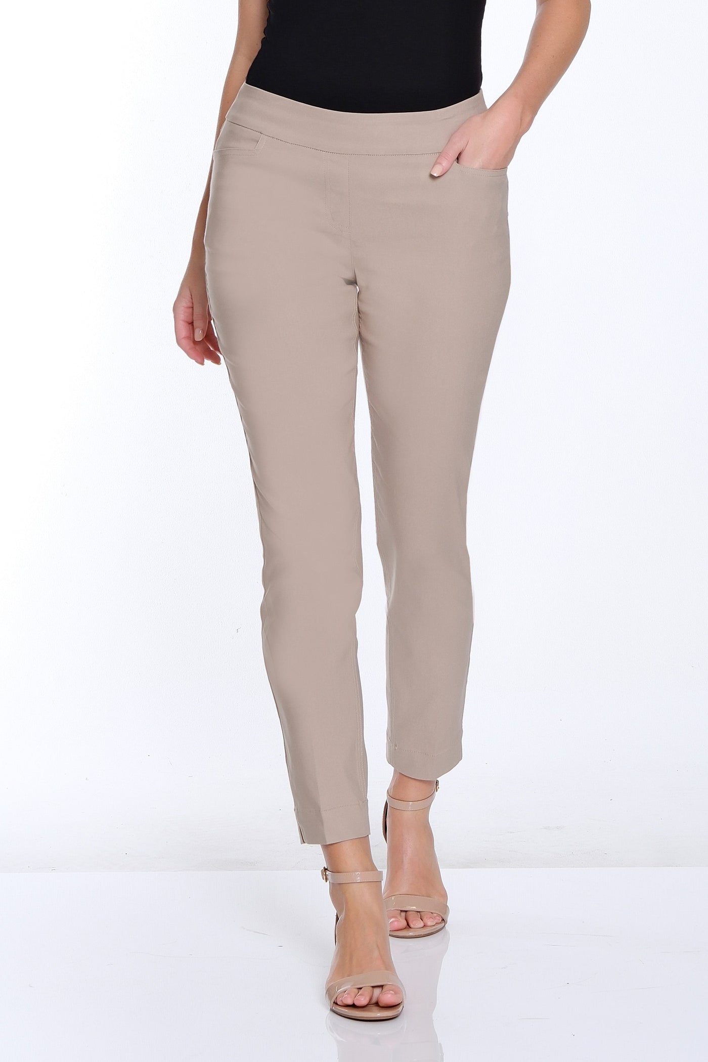 Woman wearing a black top and beige pants on a white background