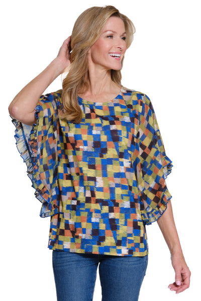 Woman wearing a colorful geometric patterned blouse with ruffled sleeves on a white background