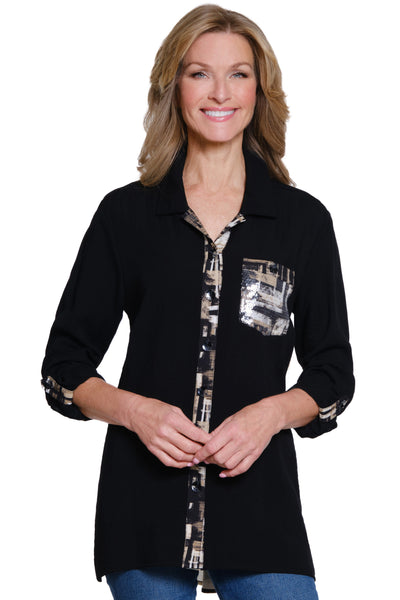 Woman wearing a black shirt with patterned accents on a white background