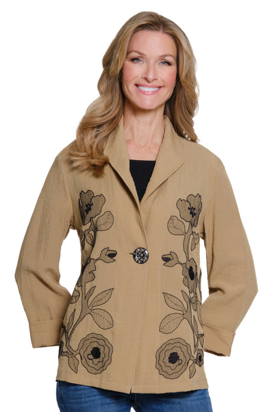 Woman wearing a beige coat with floral embroidery on a white background