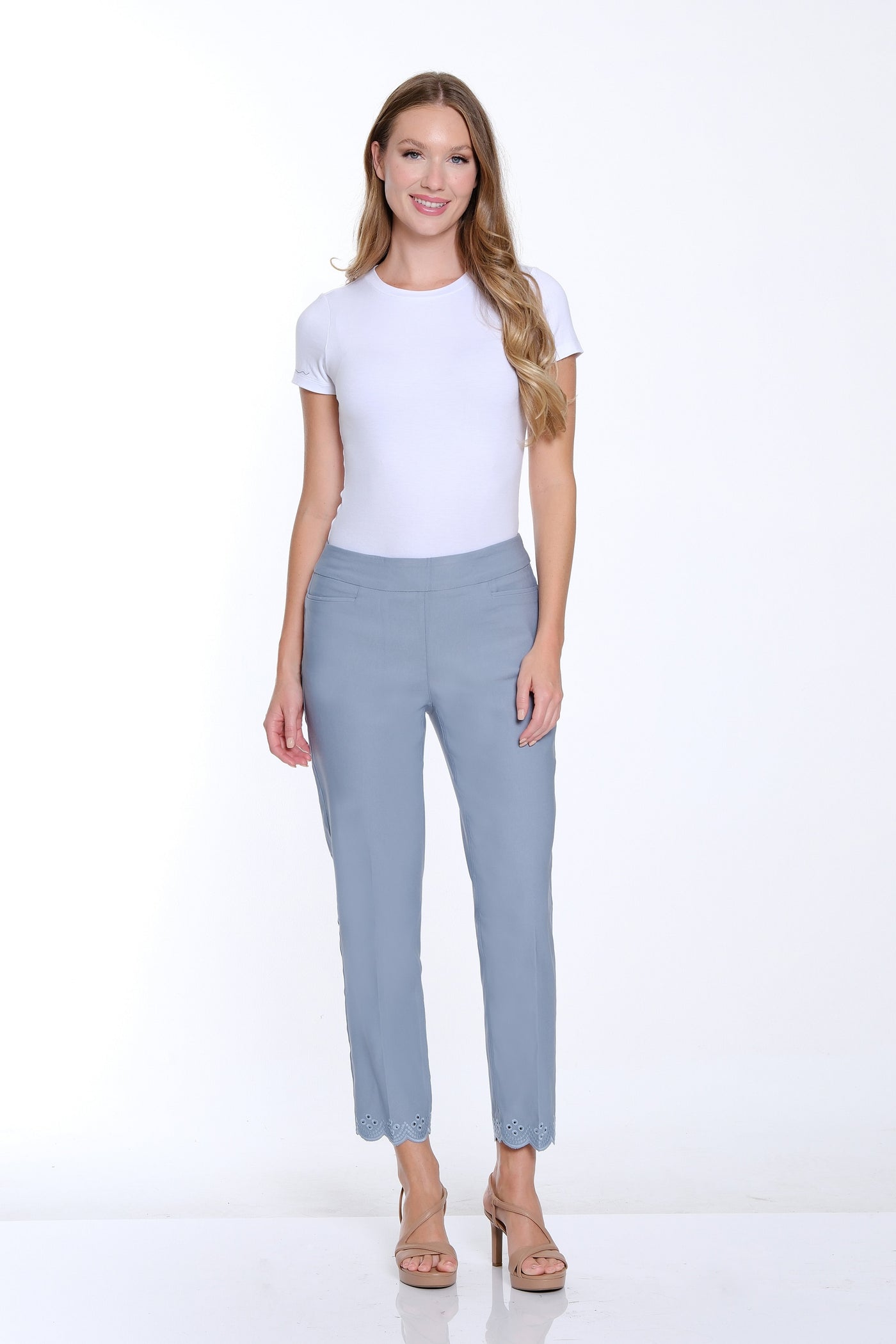 Woman wearing a white t-shirt and light gray pants on a white background