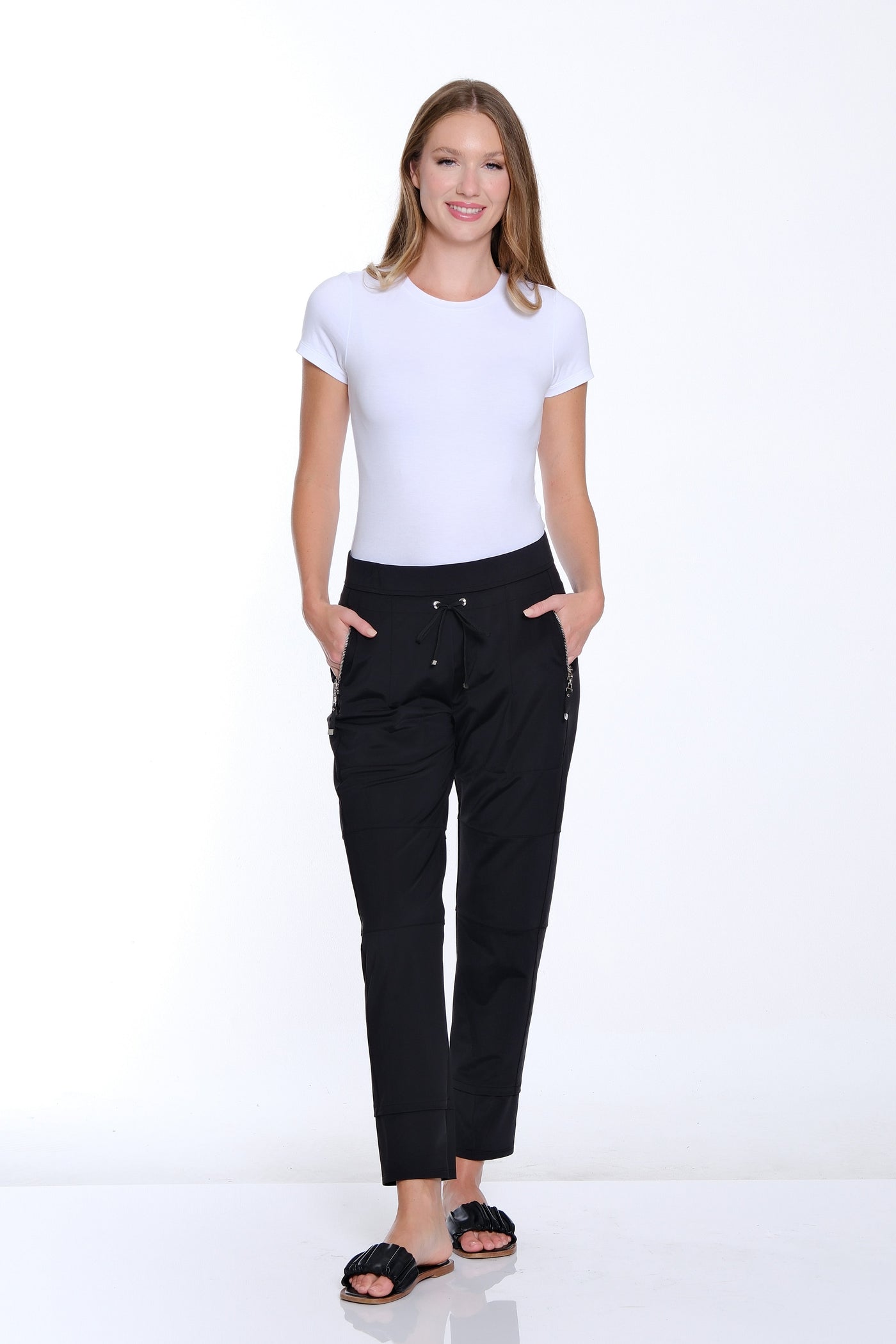 Woman wearing a white t-shirt and black pants on a white background