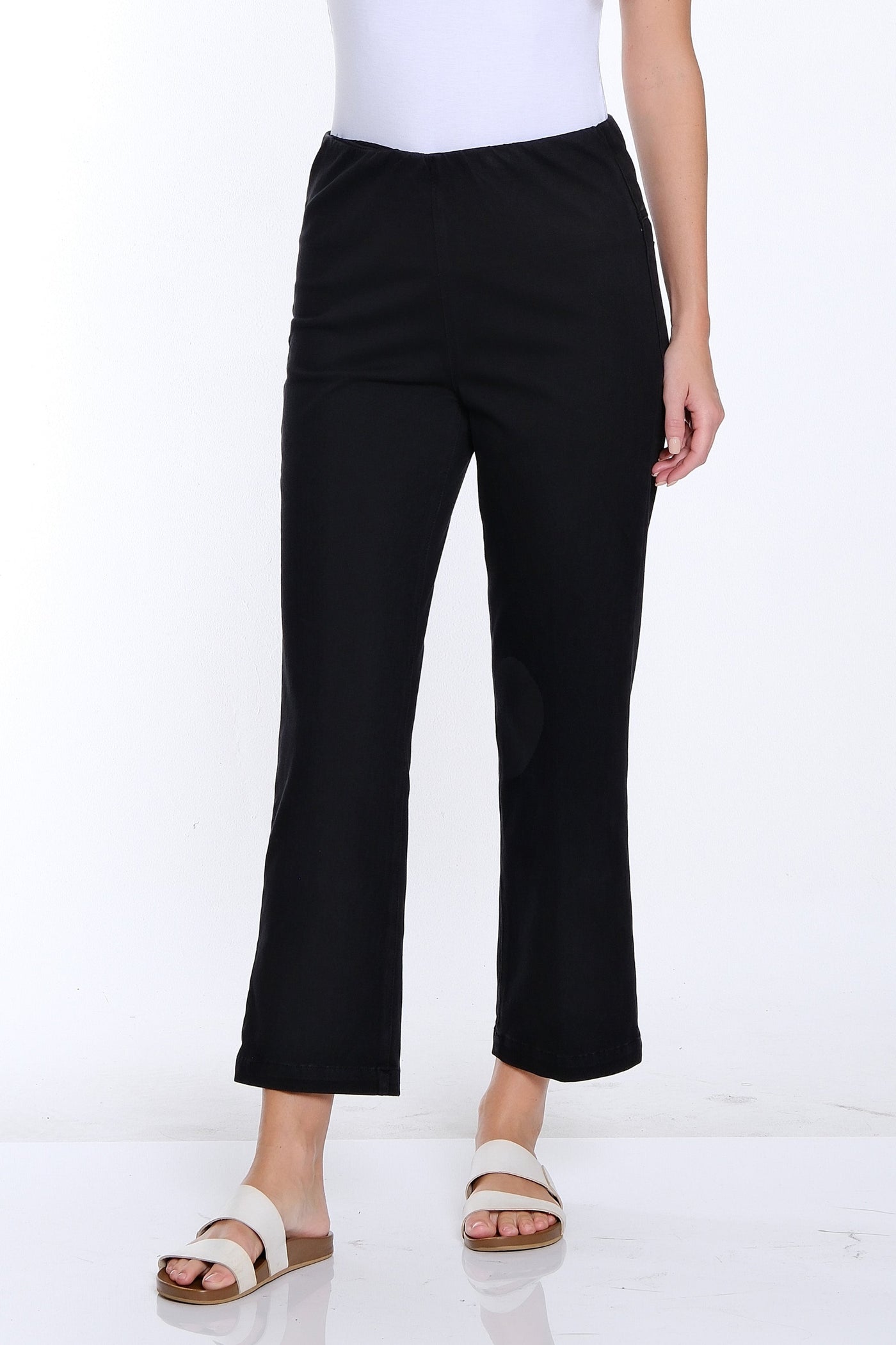 Woman wearing a white t-shirt and black pants on a white background