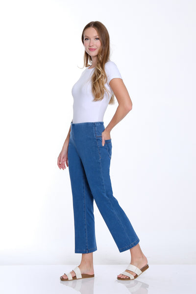 Woman wearing a white top and blue jeans on a white background