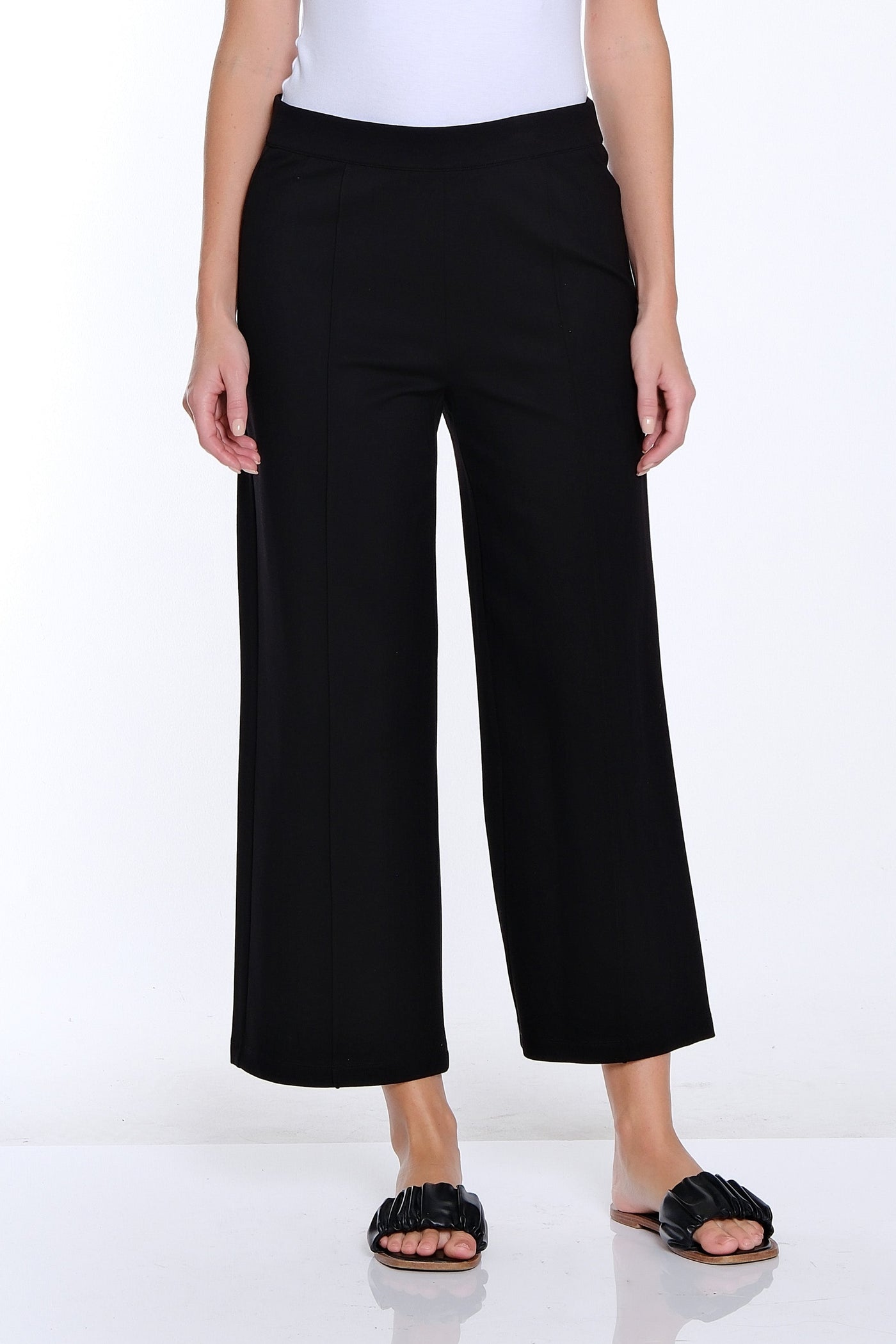 Woman wearing a white t-shirt and black wide-leg pants on a white background