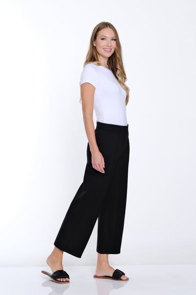 Woman wearing a white t-shirt and black pants on a white background