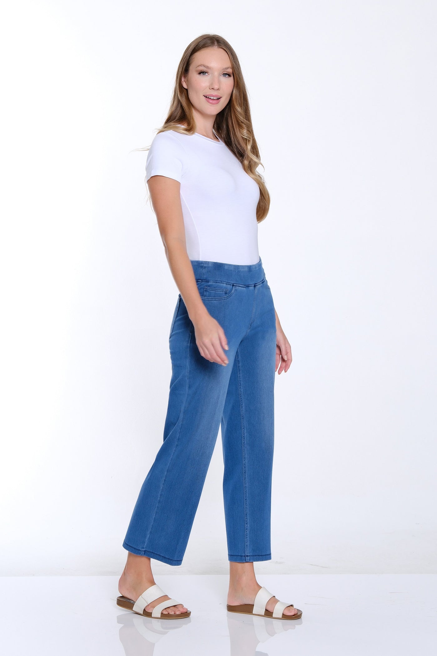 Woman wearing a white t-shirt and blue jeans on a white background