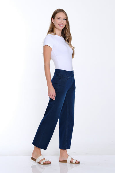 Woman wearing a white top and blue pants on a white background