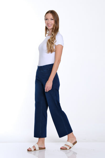 Woman wearing a white top and blue pants on a white background