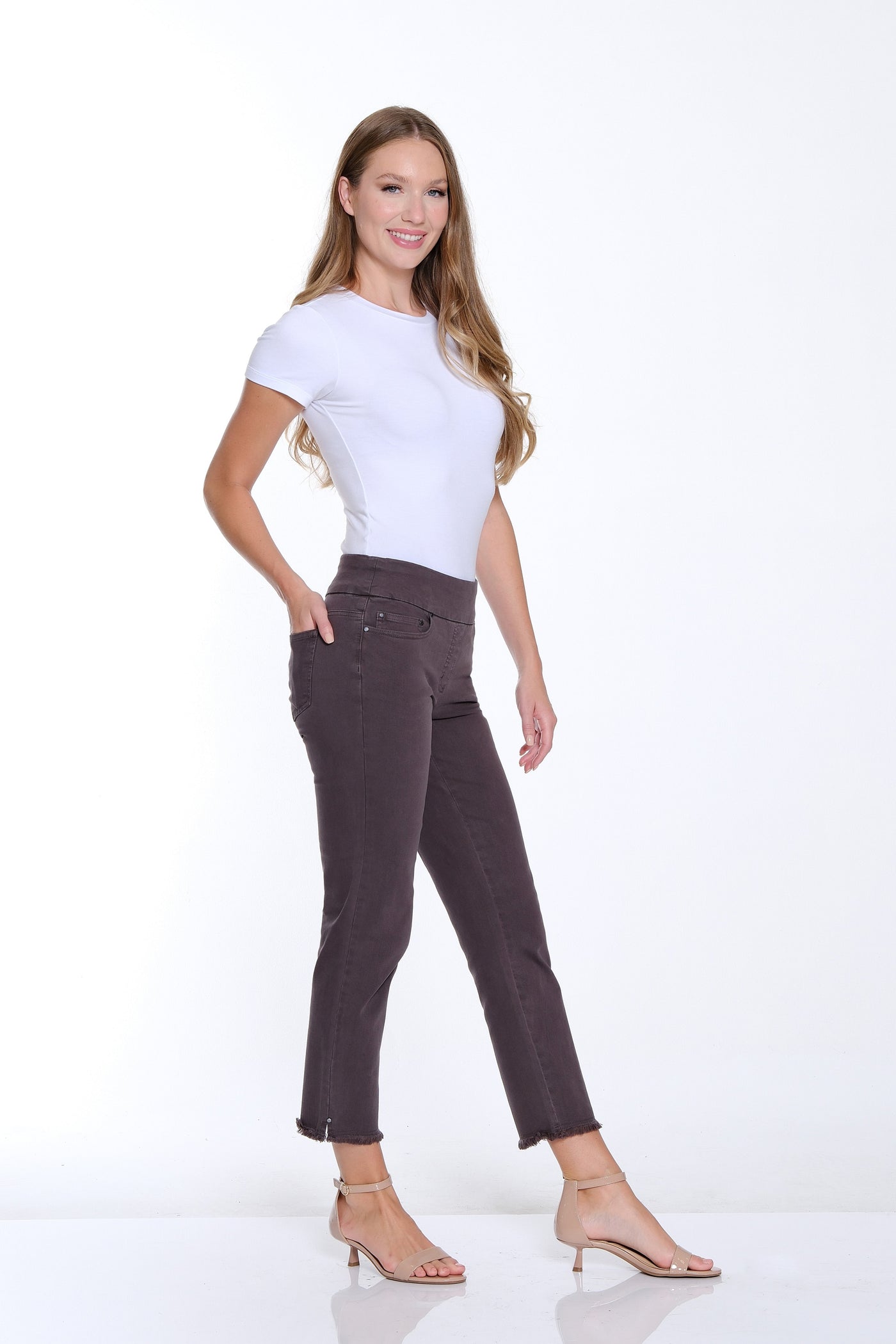 Woman wearing a white t-shirt and brown pants on a white background