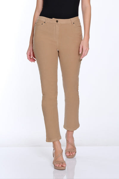 Woman wearing a black sleeveless top and beige pants on a white background