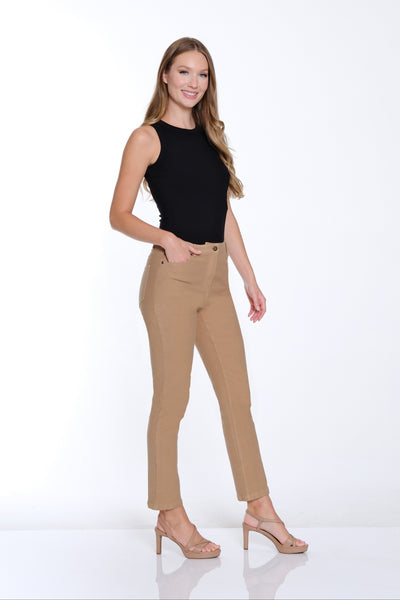 Woman wearing a black sleeveless top and beige pants on a white background