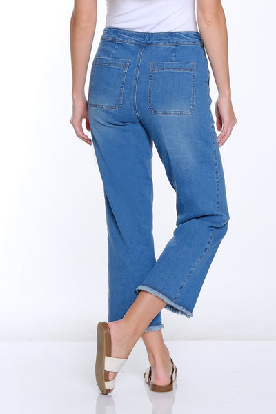 Woman wearing blue jeans and a white top on a white background