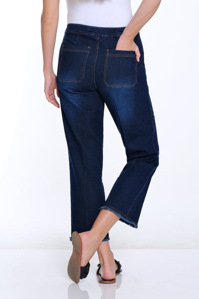 Woman wearing blue jeans and a white top on a white background