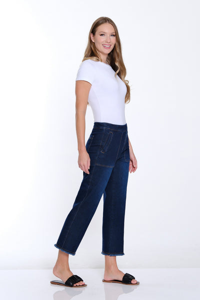 Woman wearing a white top and blue jeans on a white background