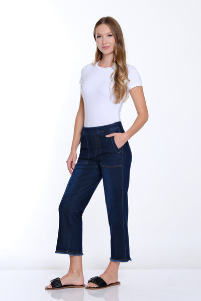 Woman wearing a white t-shirt and dark blue jeans on a white background