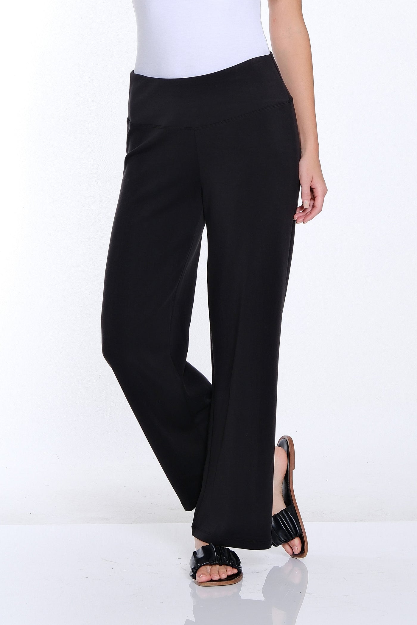 Woman wearing a white t-shirt and black pants on a white background