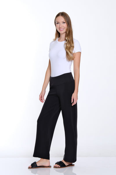 Woman wearing a white top and black pants on a white background