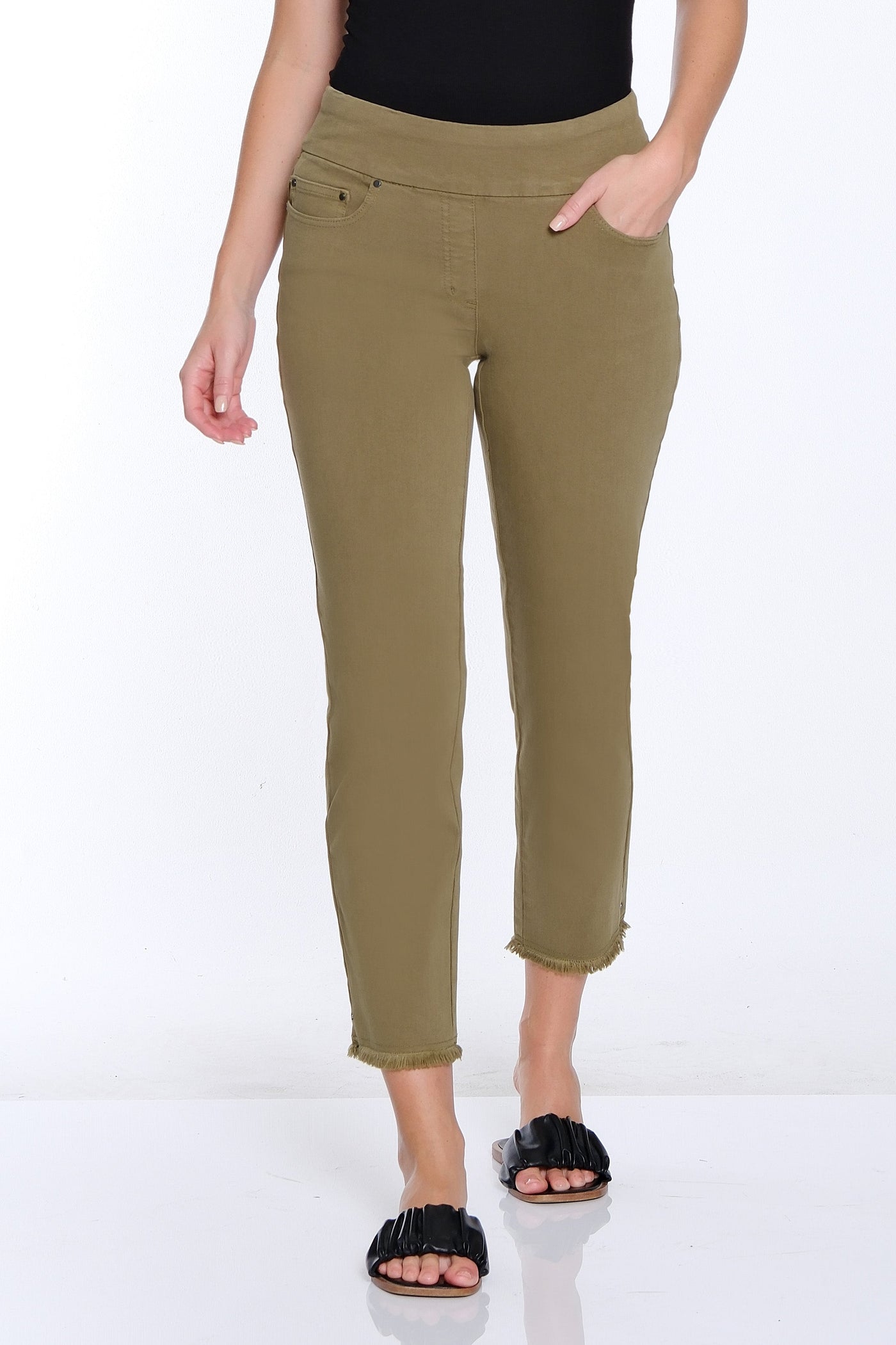 Woman wearing a black sleeveless top and green pants on a white background