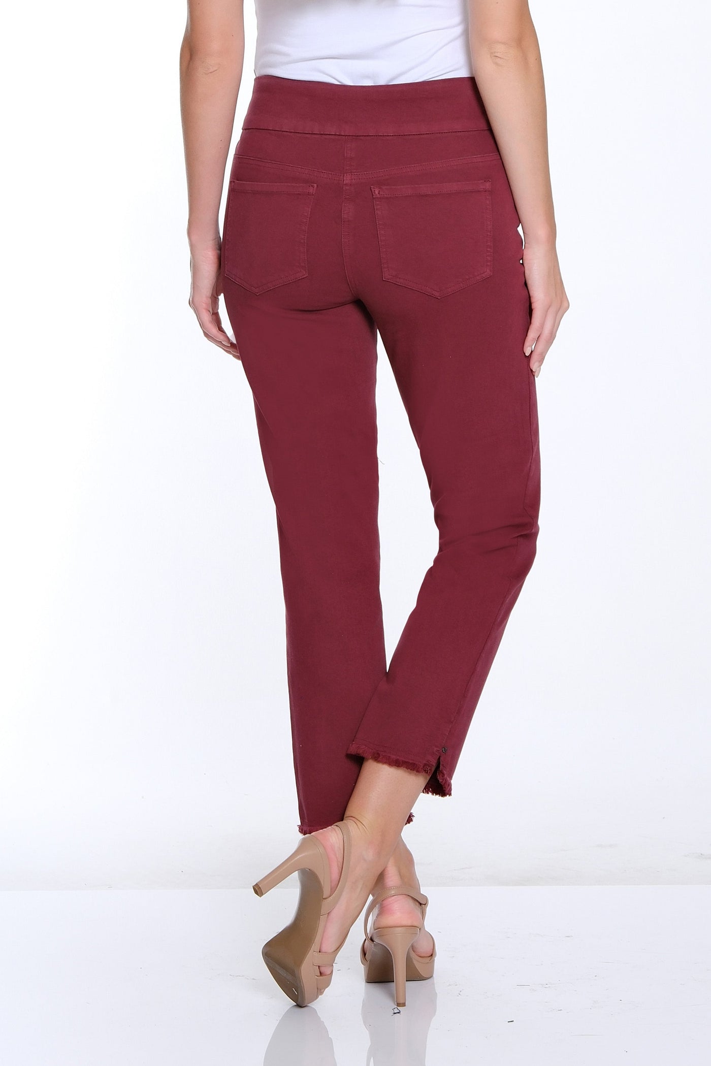 Woman wearing maroon pants and a white top on a white background