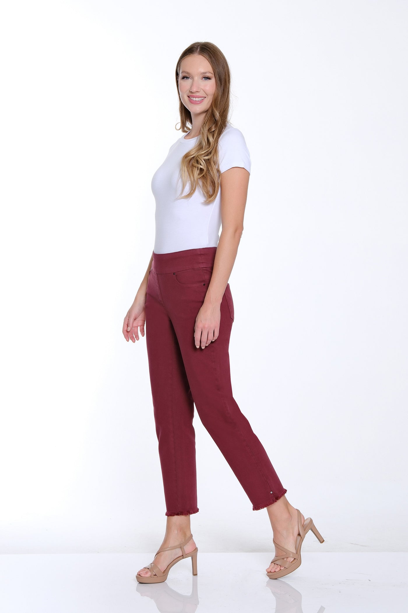 Woman wearing a white top and burgundy pants on a white background