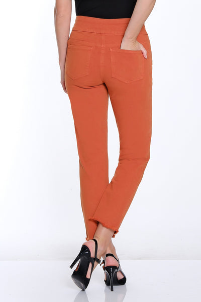 Woman wearing orange pants and black top on a white background