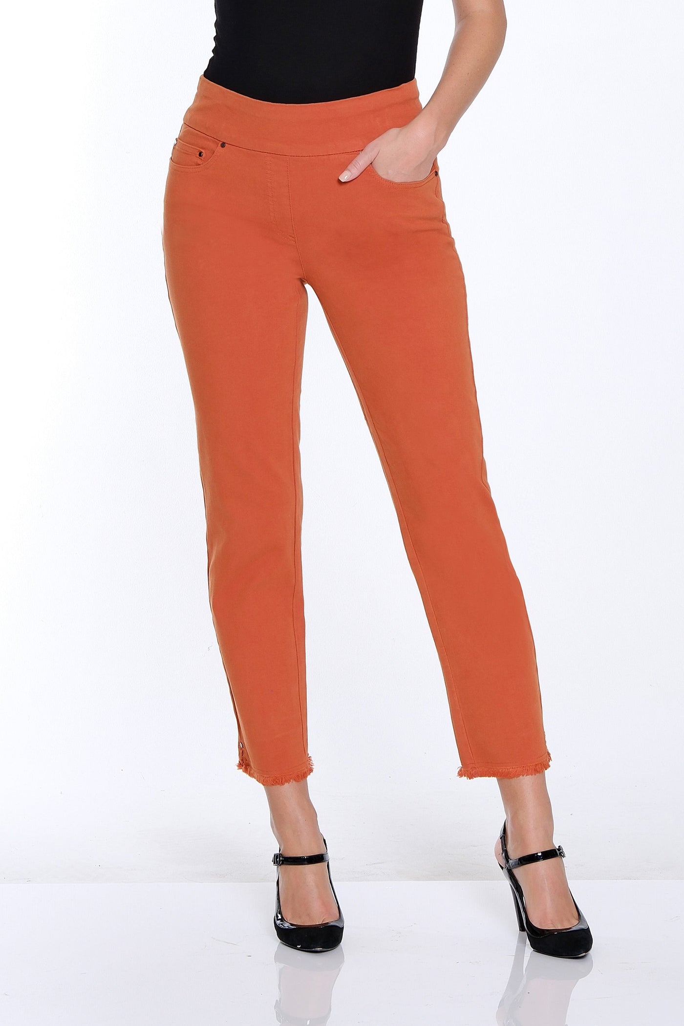 Woman wearing a black top and orange pants on a white background