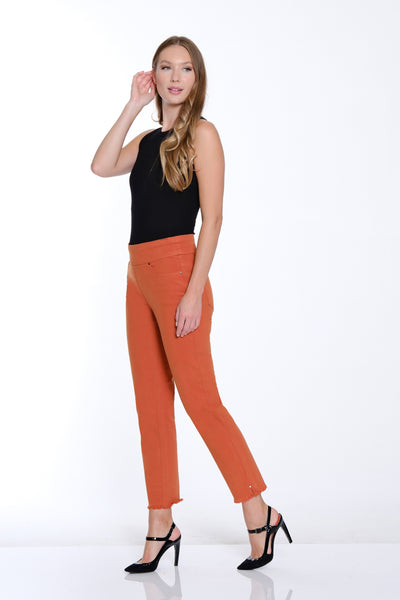 Woman wearing a black top and orange pants on a white background