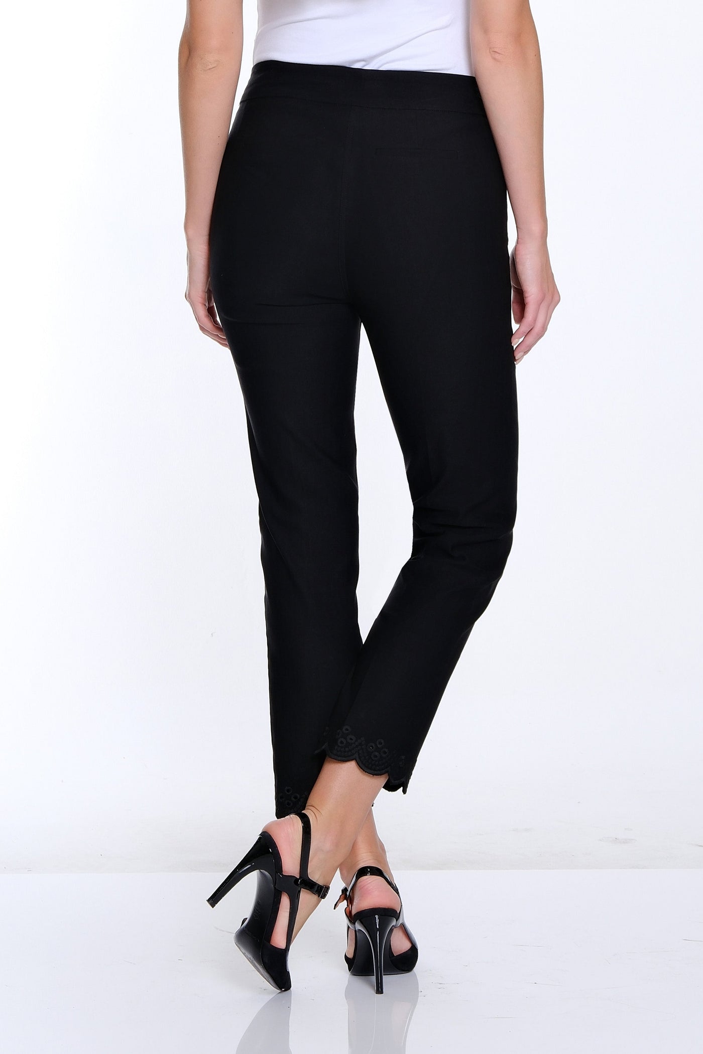 Woman wearing a white top and black pants on a white background