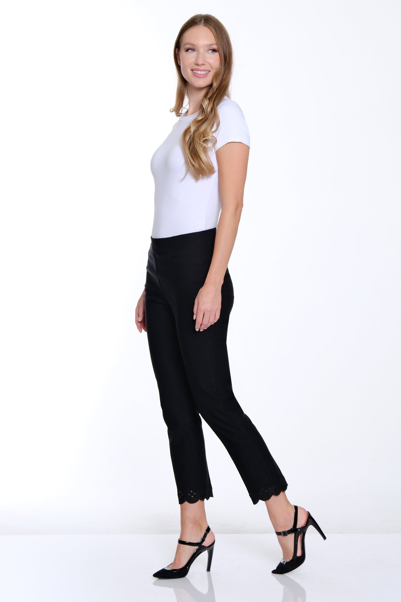 Woman wearing a white top and black pants on a white background