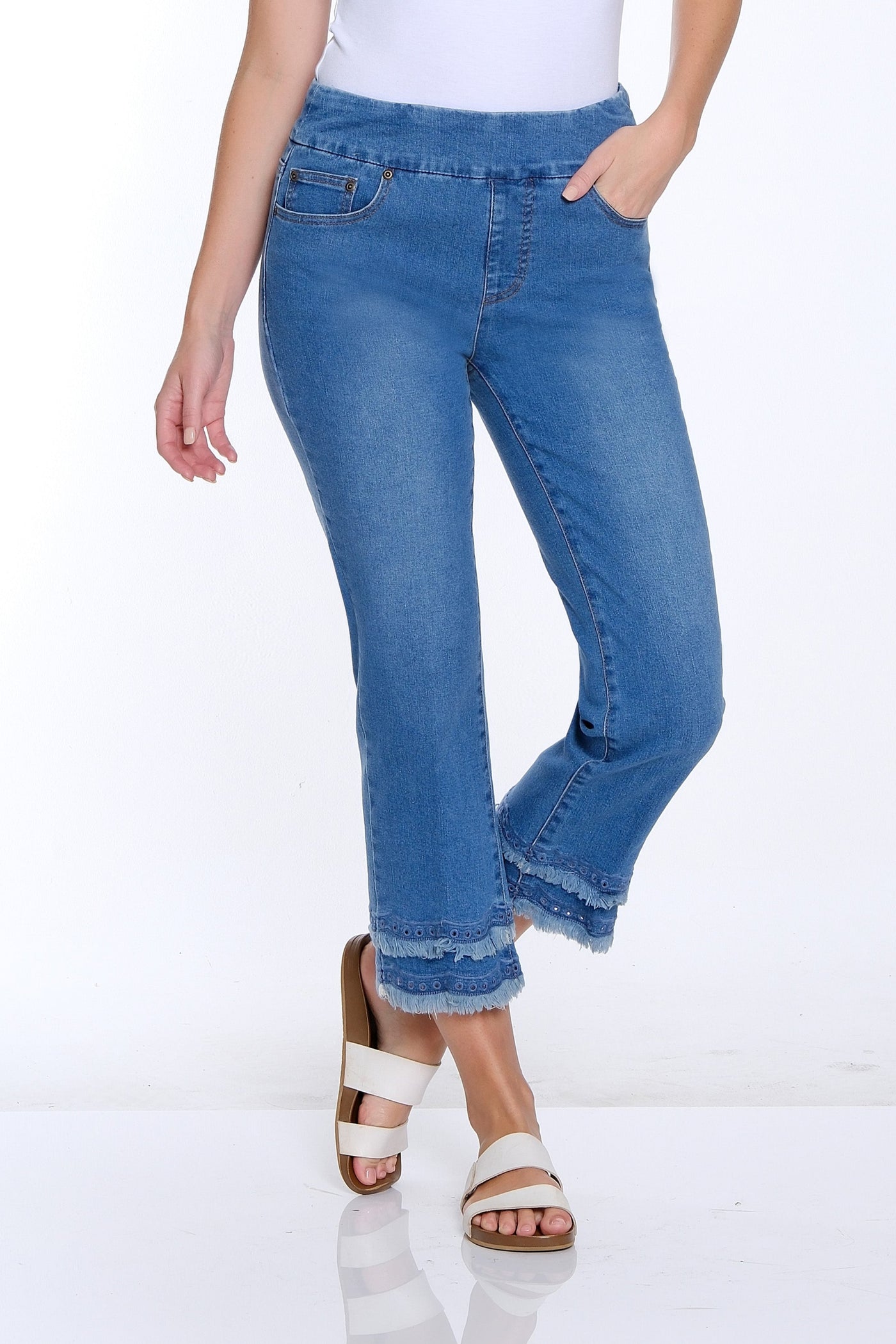 Woman wearing a white t-shirt and blue jeans on a white background