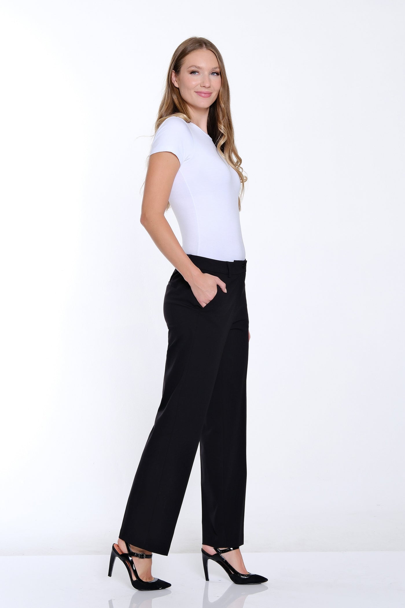 Woman wearing a white t-shirt and black pants on a white background