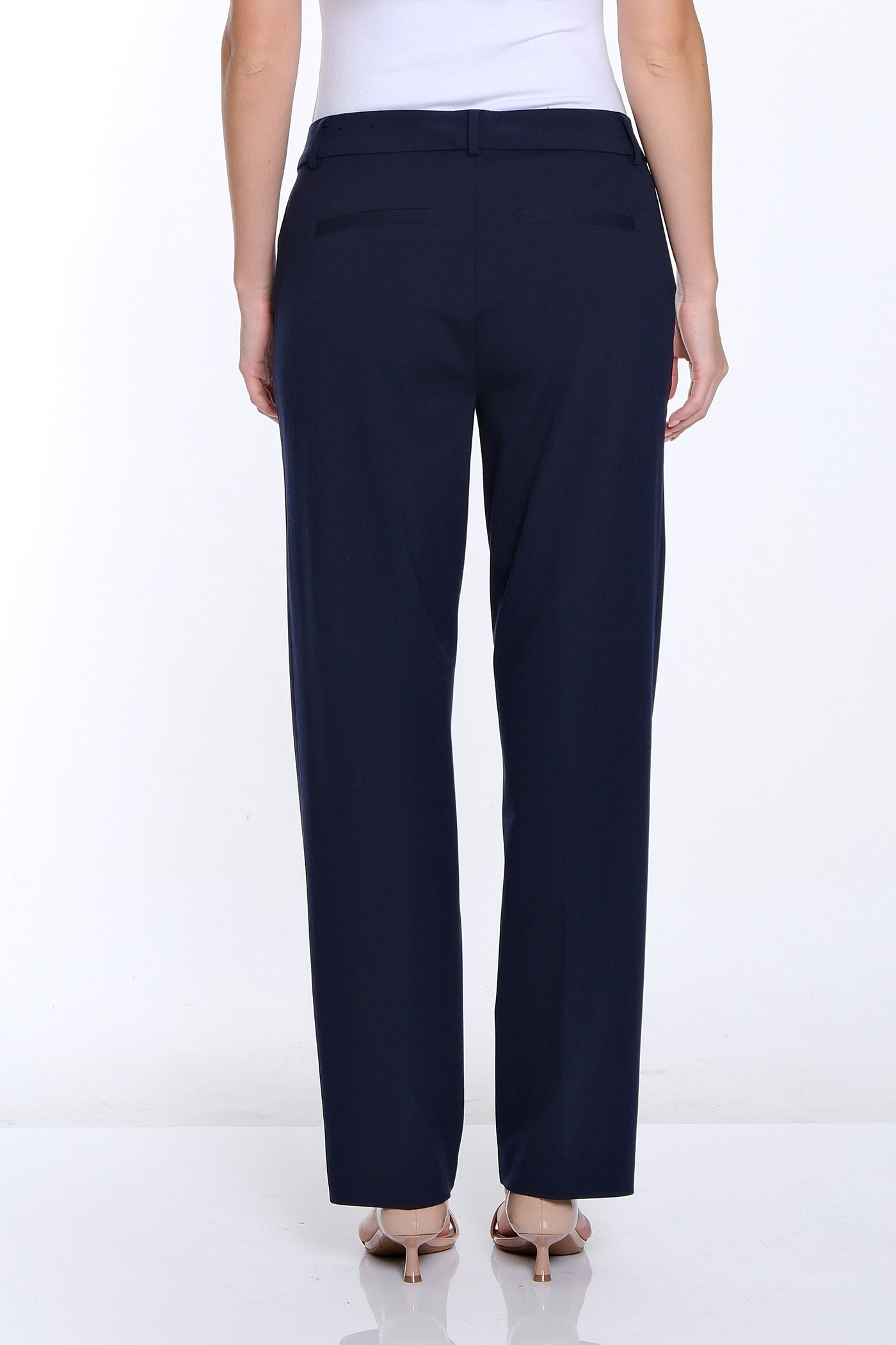 Woman wearing navy pants and a white top on a white background